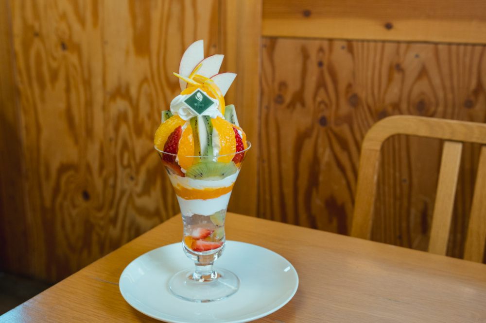 付属するフルーツパーラーでは季節のフルーツを使ったパフェやフルーツサンドをオーダーできる。7〜8月はいちばん人気のモモのフルーツパフェをお楽しみに