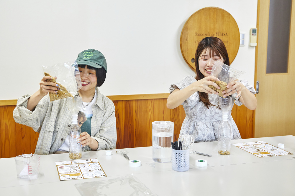① 国産の大豆・小麦・麹菌・塩を混ぜ合わせた特製醤油麹をペットボトルに入れます。